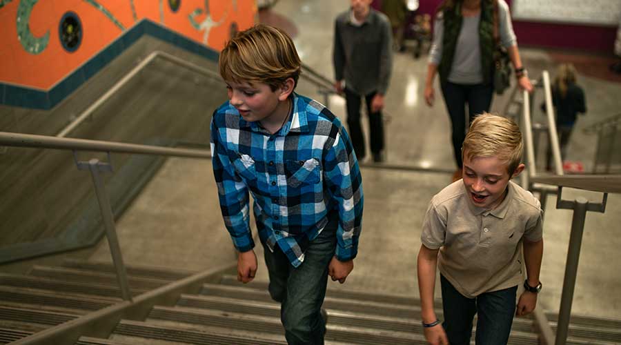 Two boys walking up stairway in Boise's Main Street Station
