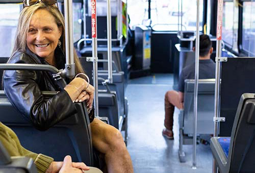 Woman riding bus and talking with another passenger