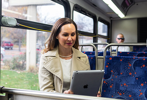 Business woman on the bus working on her tablet
